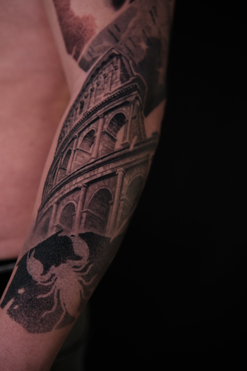Black & Grey Tattoo am Unterarm: Kolosseum in Untersicht, darunter ein Skorpion in Dotwork-Schattierung