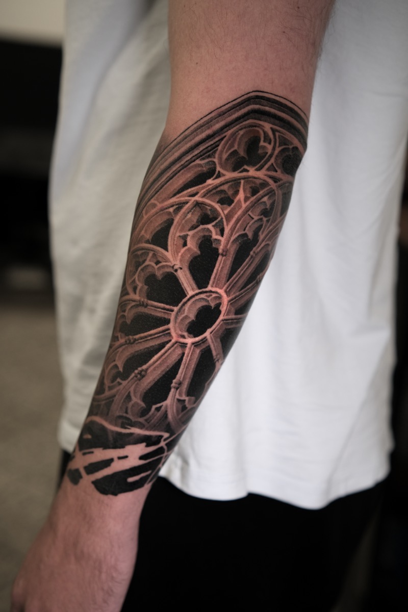 Unterarm-Tattoo: gotisches Rosettenfenster in realistischer, dreidimensionaler Schattierung